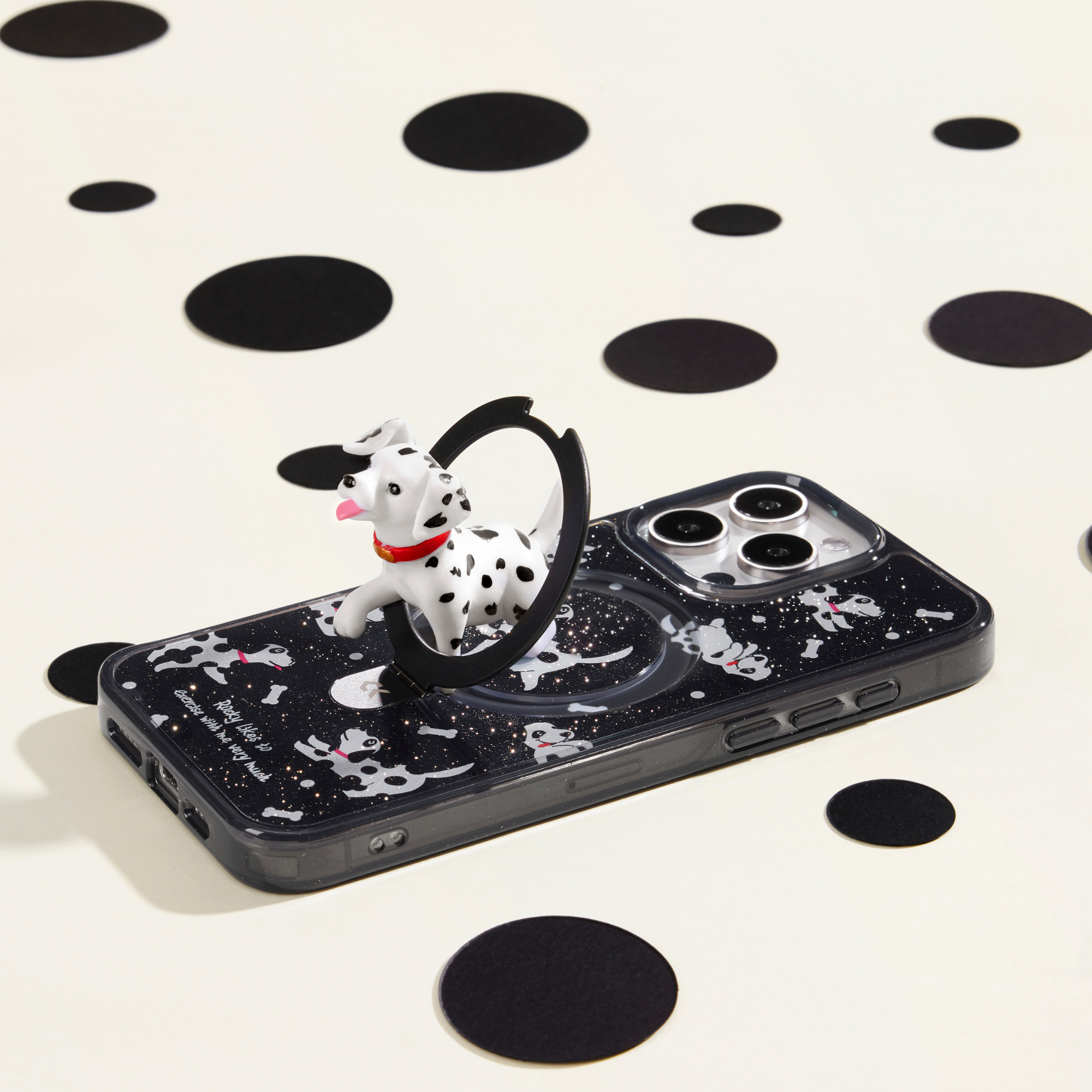 Dalmatian-themed phone case with a 3D Dalmatian ring stand, featuring playful dog patterns on a black background, surrounded by polka dot decorations