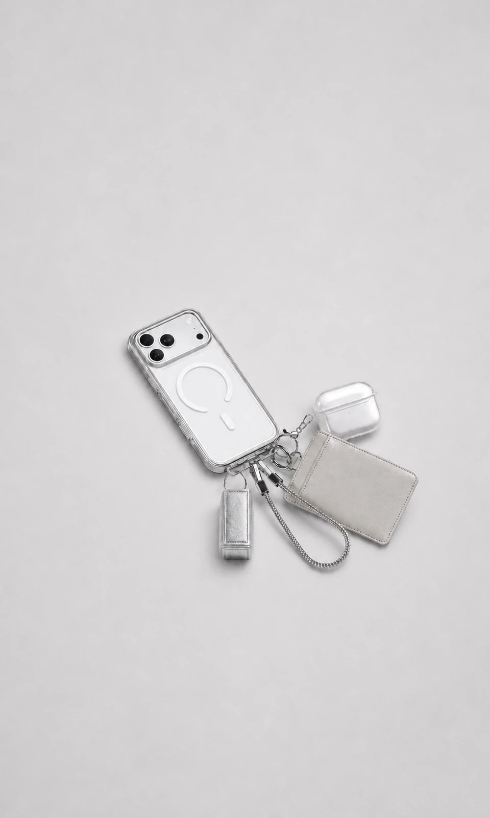 CASEKOO clear phone case and silver accessories fully visible in centered flat lay