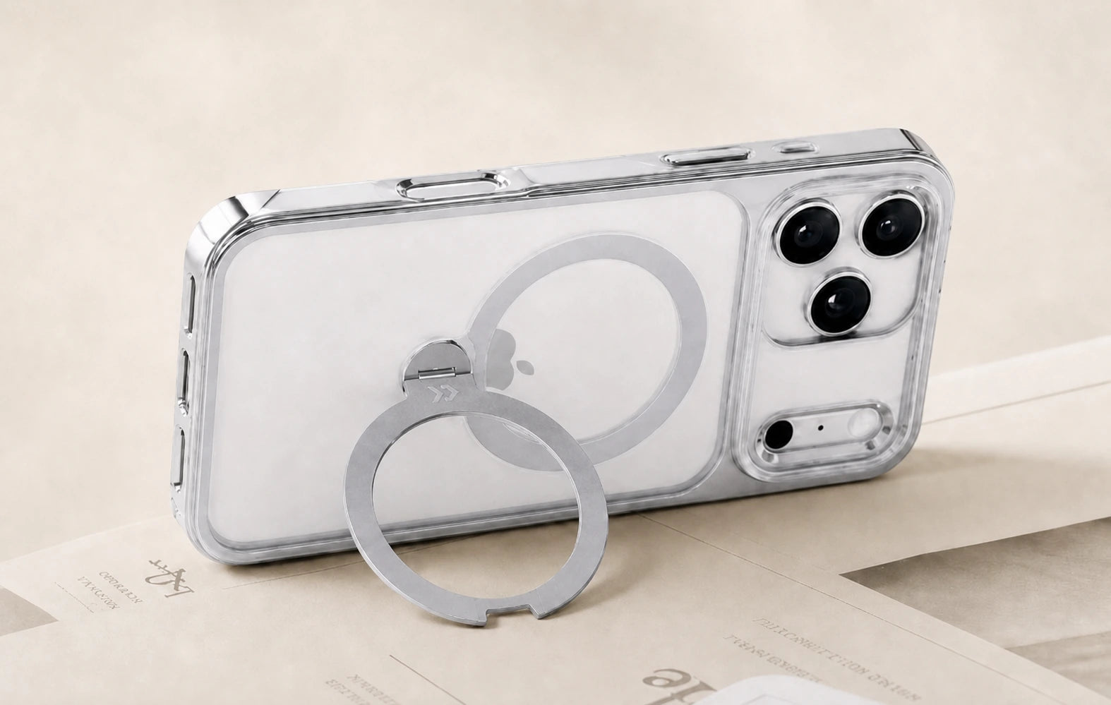 360°リングを開き、デスク上でスマートフォンを支えるシルバーのStandKOO Haloケース